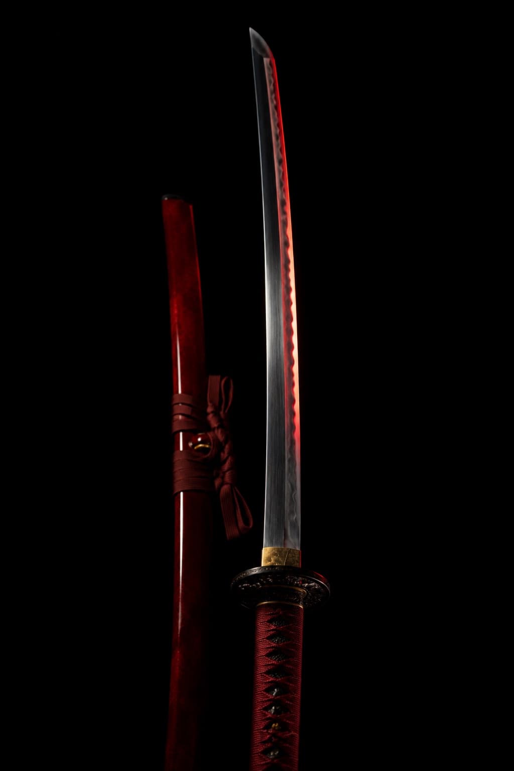 Katana held vertically beside its red lacquered sheath