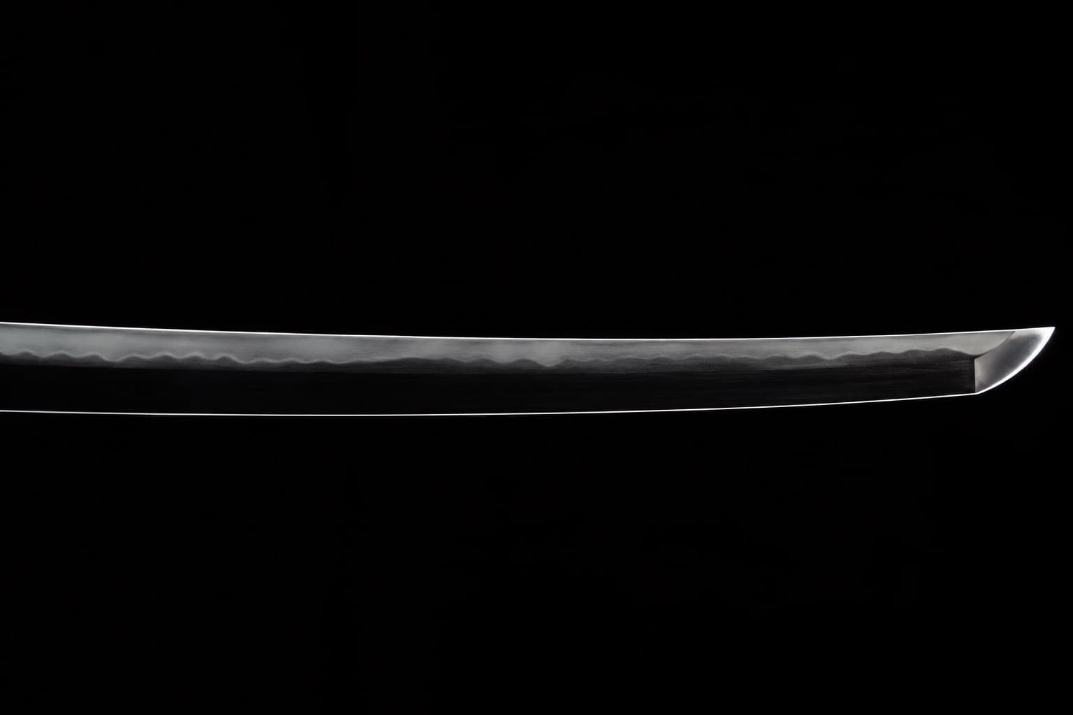 A polished katana blade rim lit on black