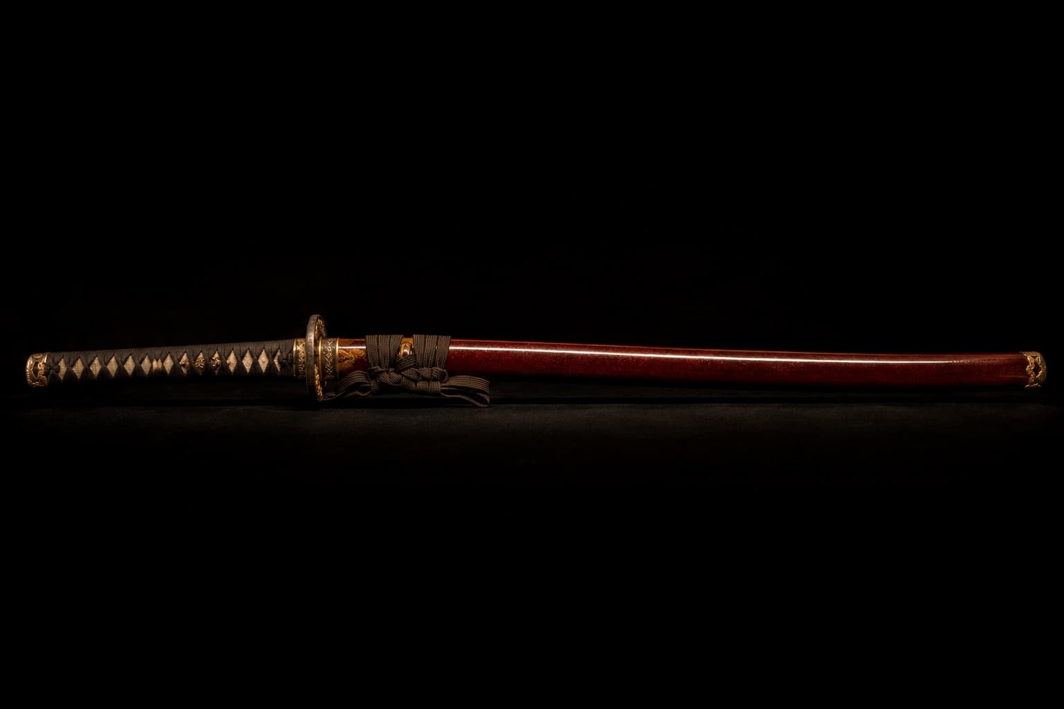 The finished katana resting in its red lacquered sheath